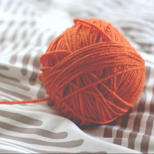 close up on an orange knitting ball