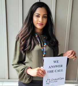 Muna S., a Client Services Supervisor holding up a sign that says We Answer the Call