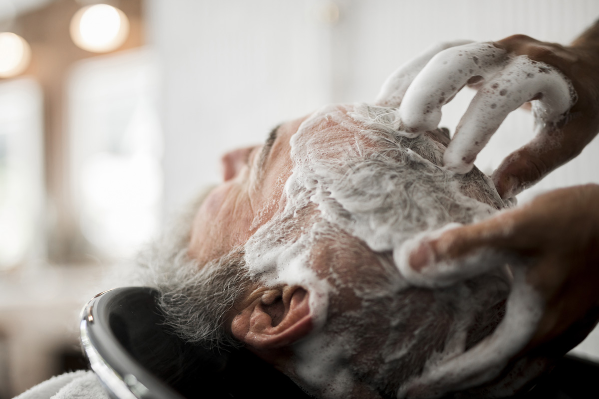 Male senior having his hair washed